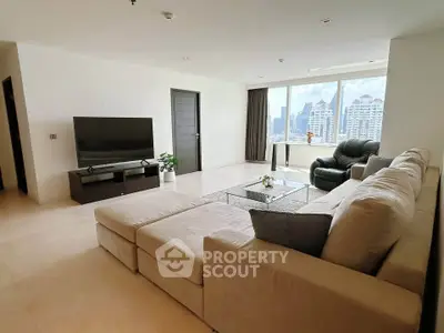 Spacious modern living room with city view, featuring a large sectional sofa and flat-screen TV.
