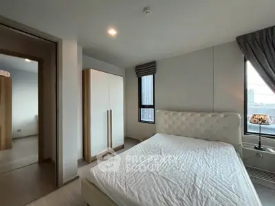 Modern bedroom with large windows and stylish decor in a high-rise apartment.