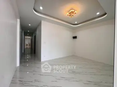 Spacious modern living room with elegant ceiling design and glossy marble flooring.