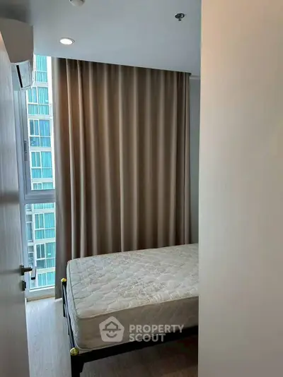 Cozy bedroom with large window and modern curtains in urban apartment