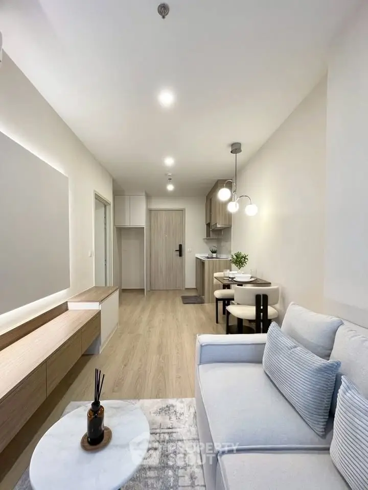 Modern living room with cozy seating and stylish dining area in open layout apartment.
