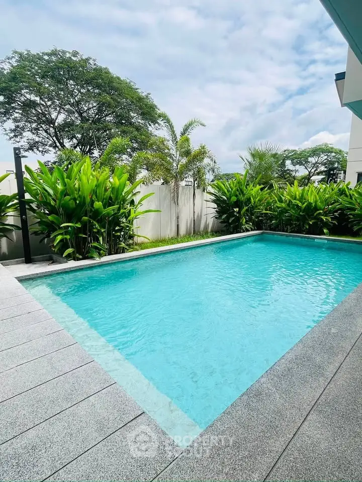 Luxurious private pool surrounded by lush greenery in a modern residential setting.