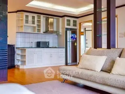 Spacious open-layout living room with modern kitchen and cozy sofa, perfect for entertaining.