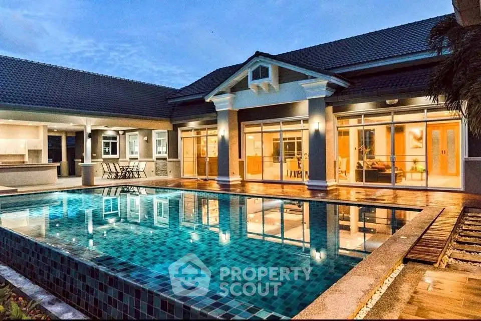 Luxurious modern home with stunning pool and elegant lighting at dusk.