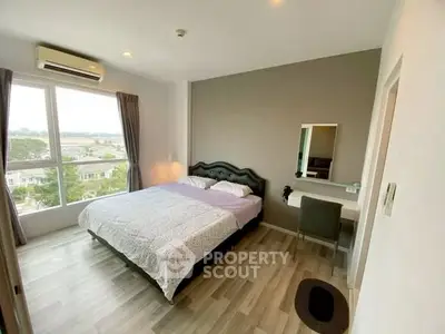 Spacious bedroom with large window and modern decor