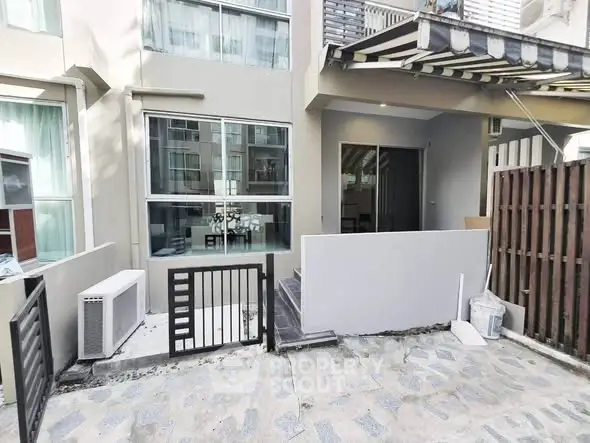 Modern townhouse exterior with gated entrance and large windows