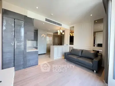 Modern living room with sleek kitchen, stylish sofa, and elegant lighting in a contemporary apartment.
