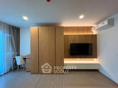 Modern living room with wooden paneling, wall-mounted TV, and air conditioning unit.