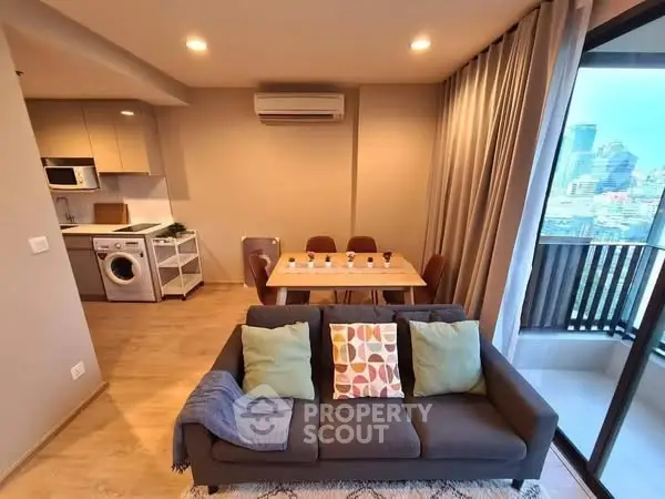 Modern open-plan living room with city view and balcony access