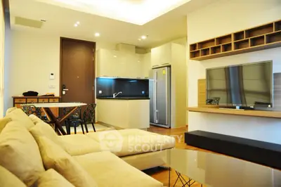 Modern open-plan living room with sleek kitchen and cozy seating area