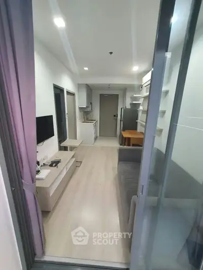 Modern apartment interior with open layout, sleek kitchen, and cozy living area.