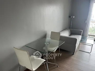 Modern living room with sleek glass table and cozy sofa, perfect for urban living.