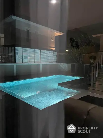 Luxurious modern home with illuminated swimming pool at night, perfect for relaxation and entertainment.