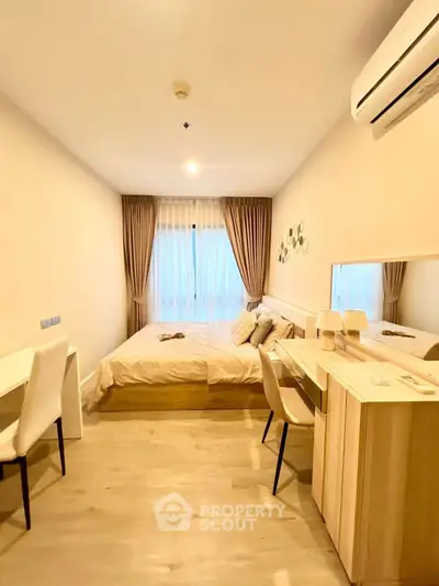 Cozy bedroom with modern decor and natural light, featuring a stylish desk and comfortable bed.