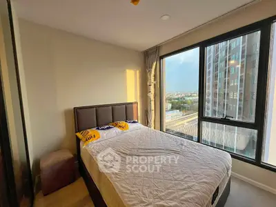 Modern bedroom with large windows offering stunning city views in a high-rise apartment.