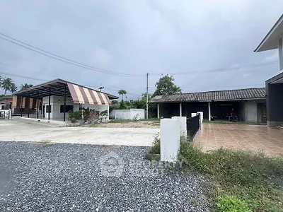 Charming suburban property with spacious driveway and covered parking area.
