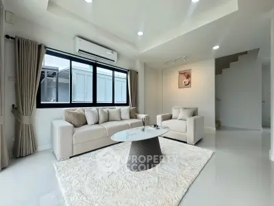 Modern living room with elegant decor, featuring a cozy sofa, stylish coffee table, and large window for natural light.