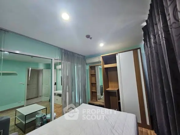 Spacious bedroom with mirrored closet and modern decor in a stylish apartment.