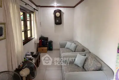 Cozy living room with elegant sofas and wall clock, perfect for relaxation.