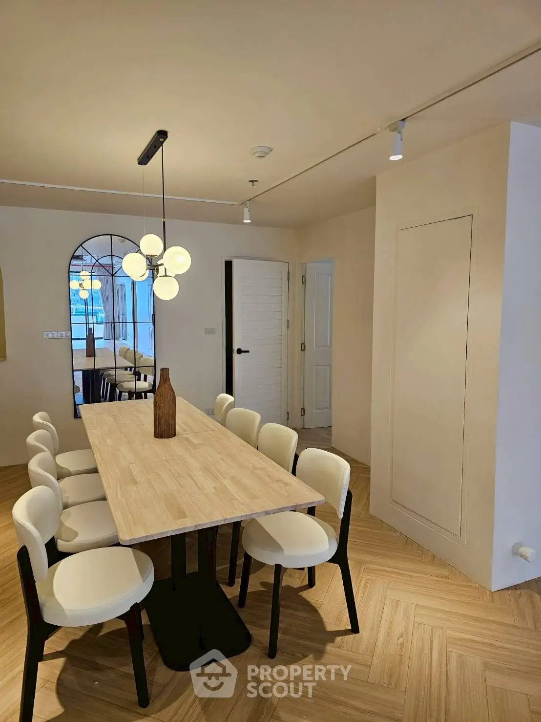 Elegant dining room with modern lighting and stylish wooden table, perfect for hosting gatherings.