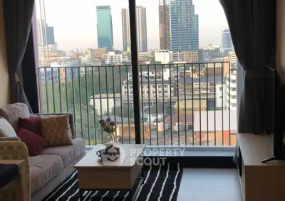 Modern living room with city view from balcony, featuring cozy sofa and stylish decor.