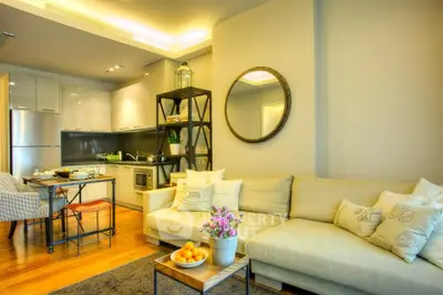 Modern living room with open kitchen, cozy sofa, and stylish decor in a contemporary apartment.