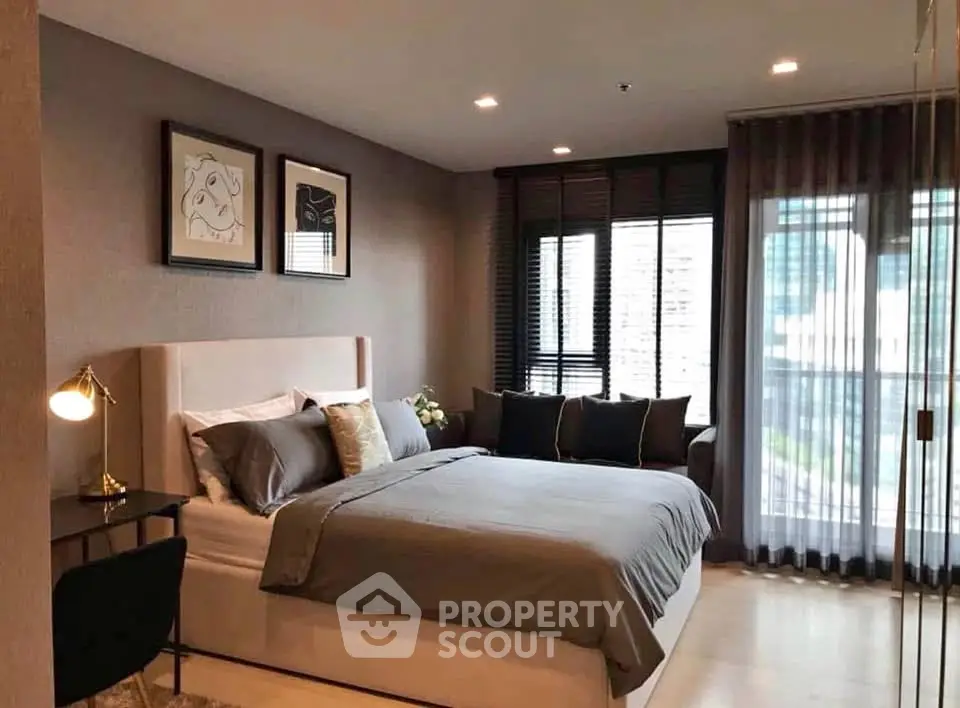 Elegant bedroom with modern decor and large windows offering natural light.