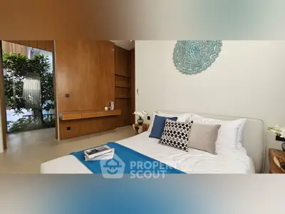 Luxurious bedroom with modern decor and natural light, featuring elegant wooden accents and stylish cushions.