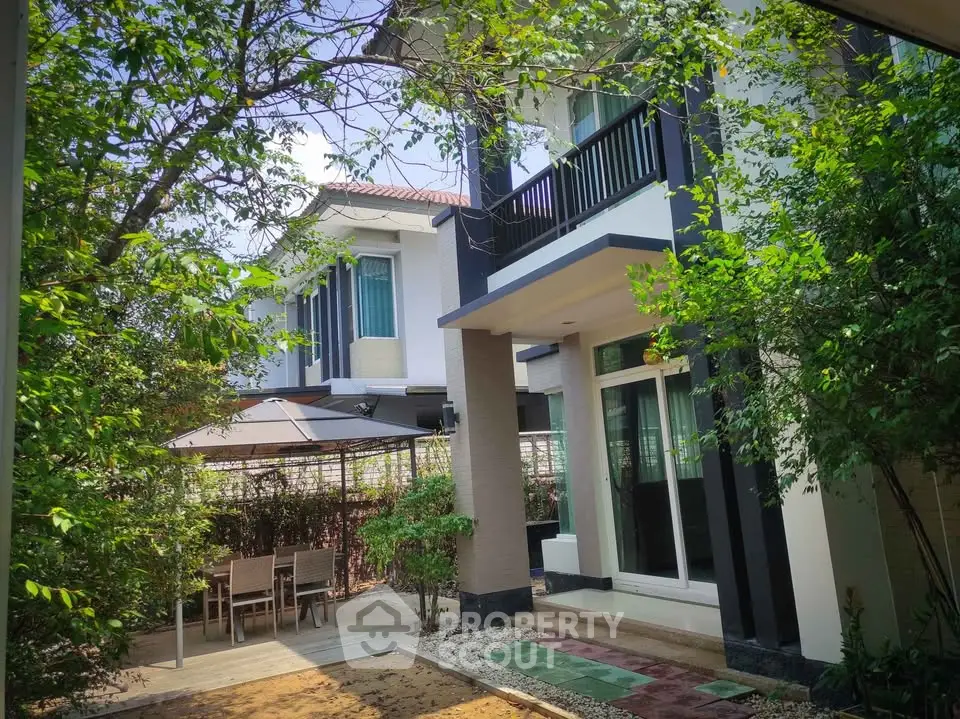 Charming modern house with lush garden and outdoor dining area, perfect for family gatherings.