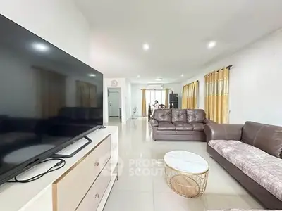 Spacious living room with modern furniture and large TV, perfect for family gatherings.