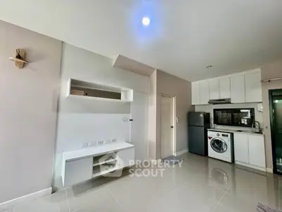 Modern kitchen with sleek appliances and ample storage in a stylish apartment.