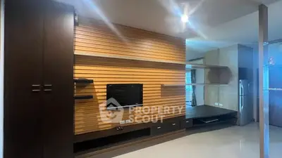 Modern living room with sleek wooden paneling and built-in TV unit
