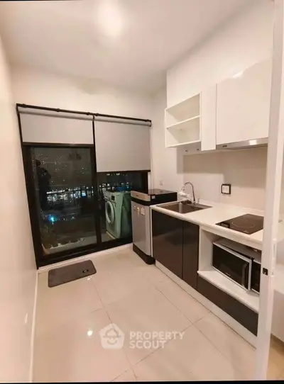 Modern kitchen with sleek appliances and city view, featuring open layout and stylish design.