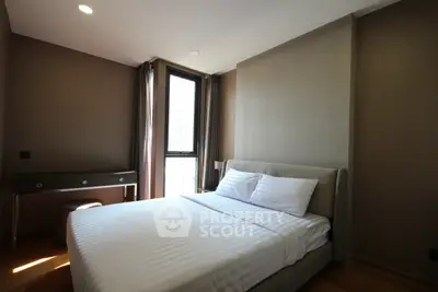 Modern bedroom with sleek design and natural light, featuring a comfortable bed and stylish desk.