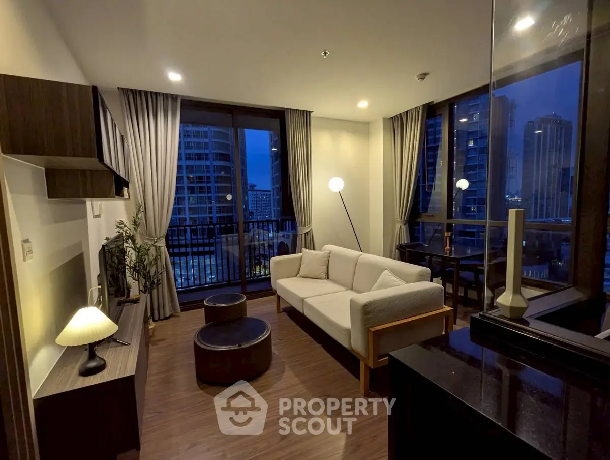 Modern living room with city view, stylish furniture, and ambient lighting in a high-rise apartment.