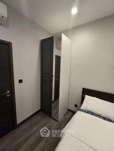 Modern bedroom with sleek design and mirrored wardrobe