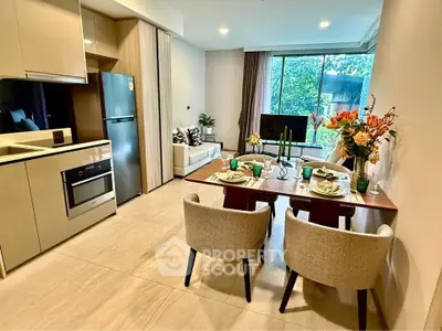 Modern open-layout kitchen and living area with elegant dining setup and large window view.
