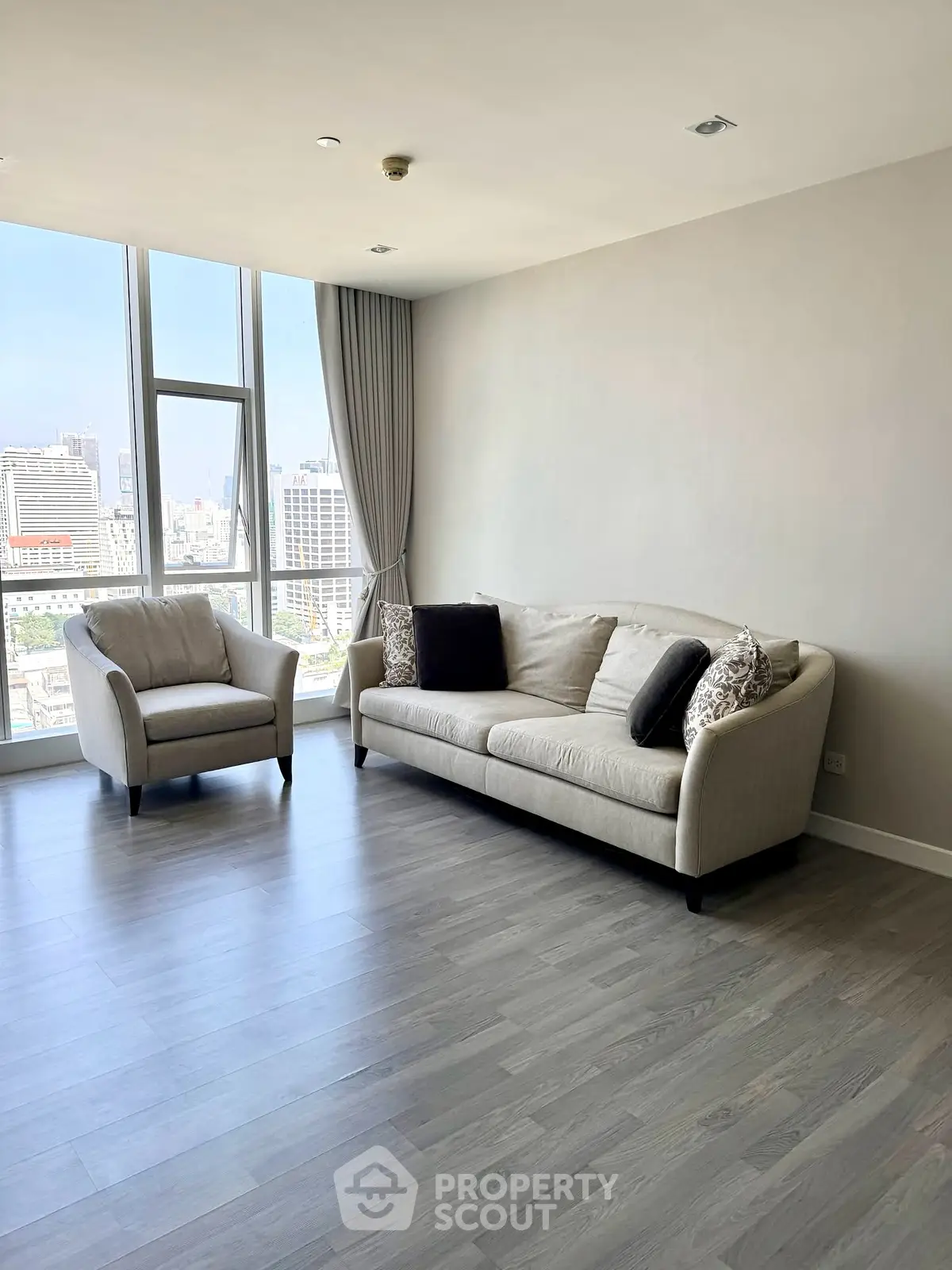 Spacious living room with modern furniture and city view, perfect for urban living.