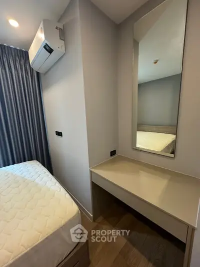 Cozy bedroom with modern air conditioning and sleek vanity mirror