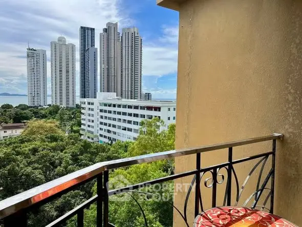 Stunning cityscape view from a cozy balcony with modern railing and vibrant seating.