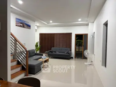 Spacious modern living room with sleek furniture and large windows, perfect for relaxation and entertaining.