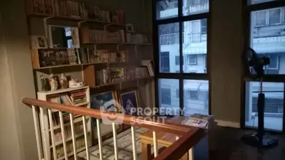 Cozy study nook with bookshelves and large windows in urban apartment