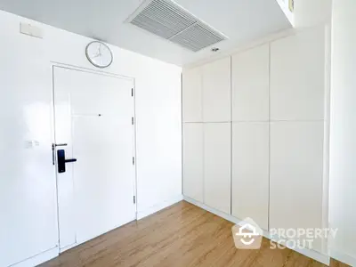 Minimalist interior with white door and built-in storage cabinets