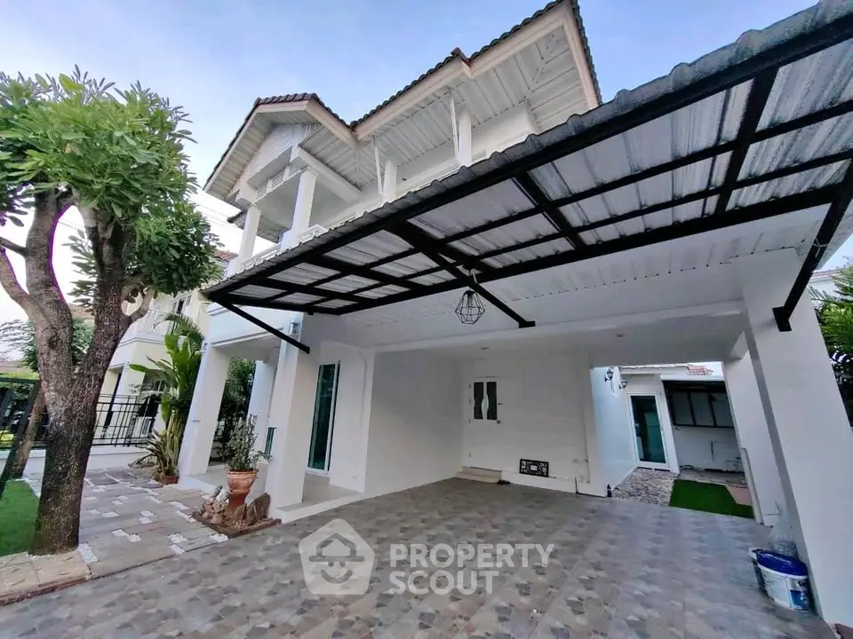 Spacious modern house with covered carport and lush garden, perfect for family living.