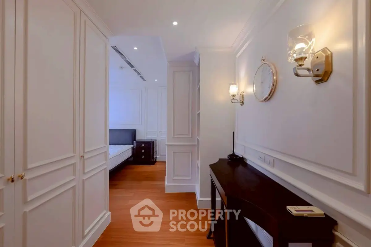 Elegant hallway leading to a cozy bedroom with classic decor and warm lighting.