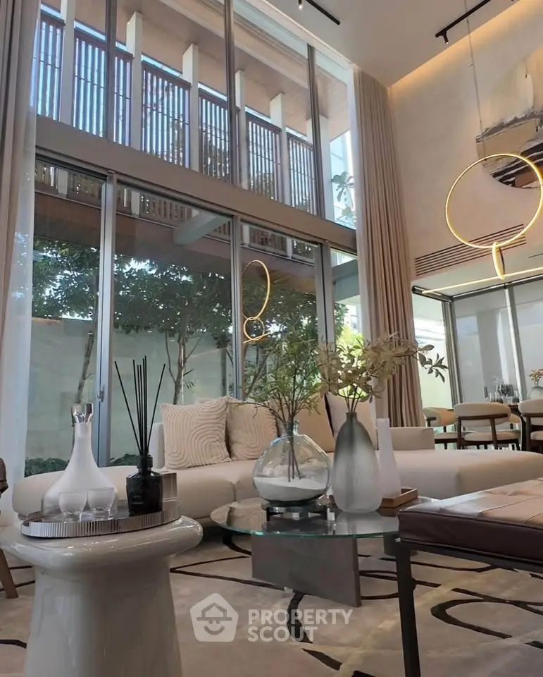 Luxurious living room with high ceilings, elegant decor, and floor-to-ceiling windows offering stunning natural light.