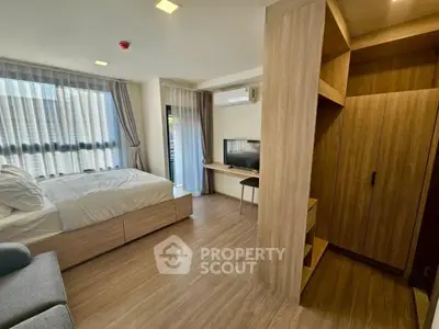 Modern bedroom with wooden flooring and natural light