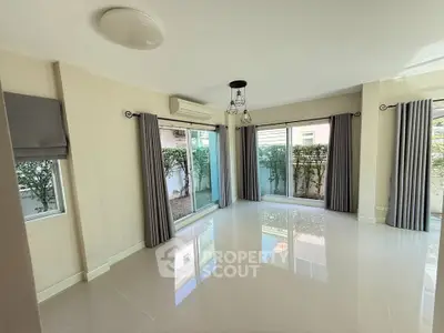 Spacious living room with large windows and modern curtains in a bright home