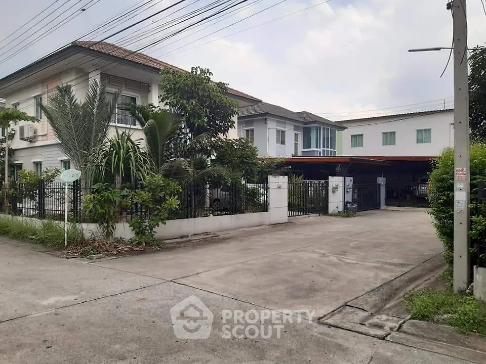 Spacious suburban house with lush greenery and ample driveway space.