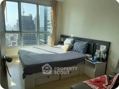 Modern bedroom with city view, featuring large windows and stylish decor.